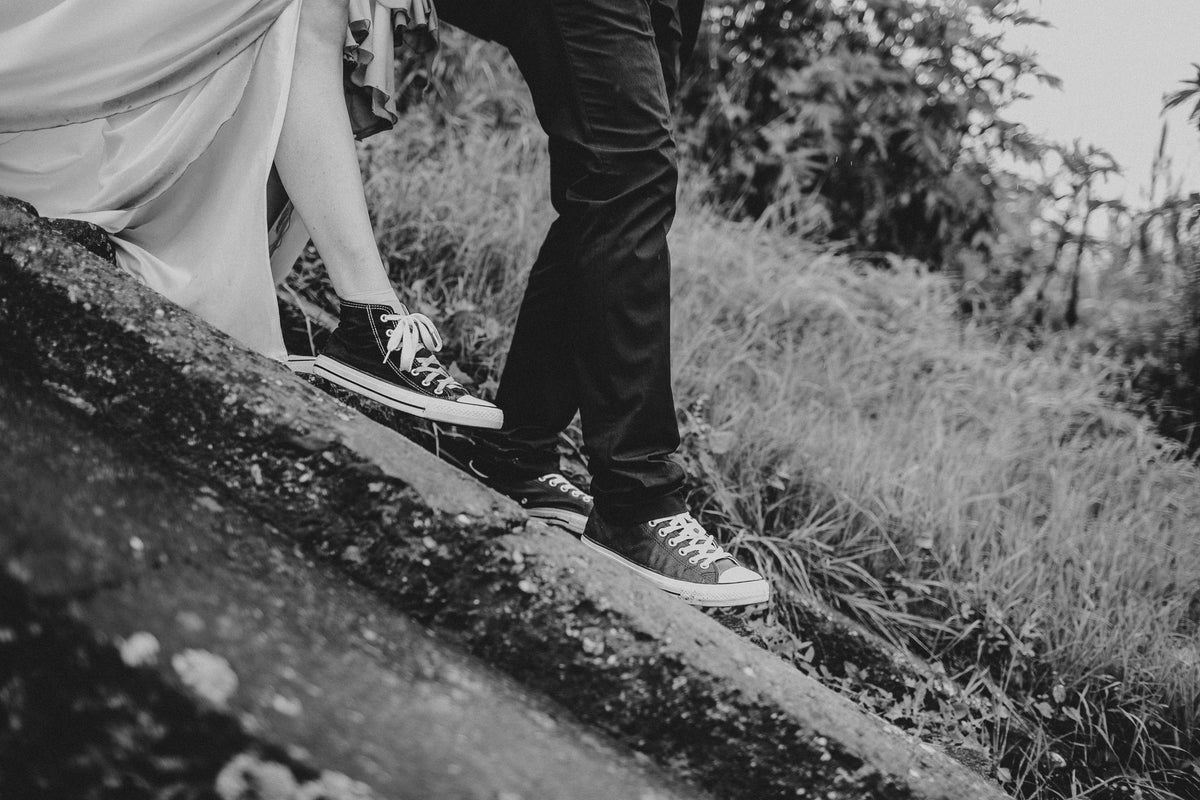 Bride and groom walking side by side in sneakers
